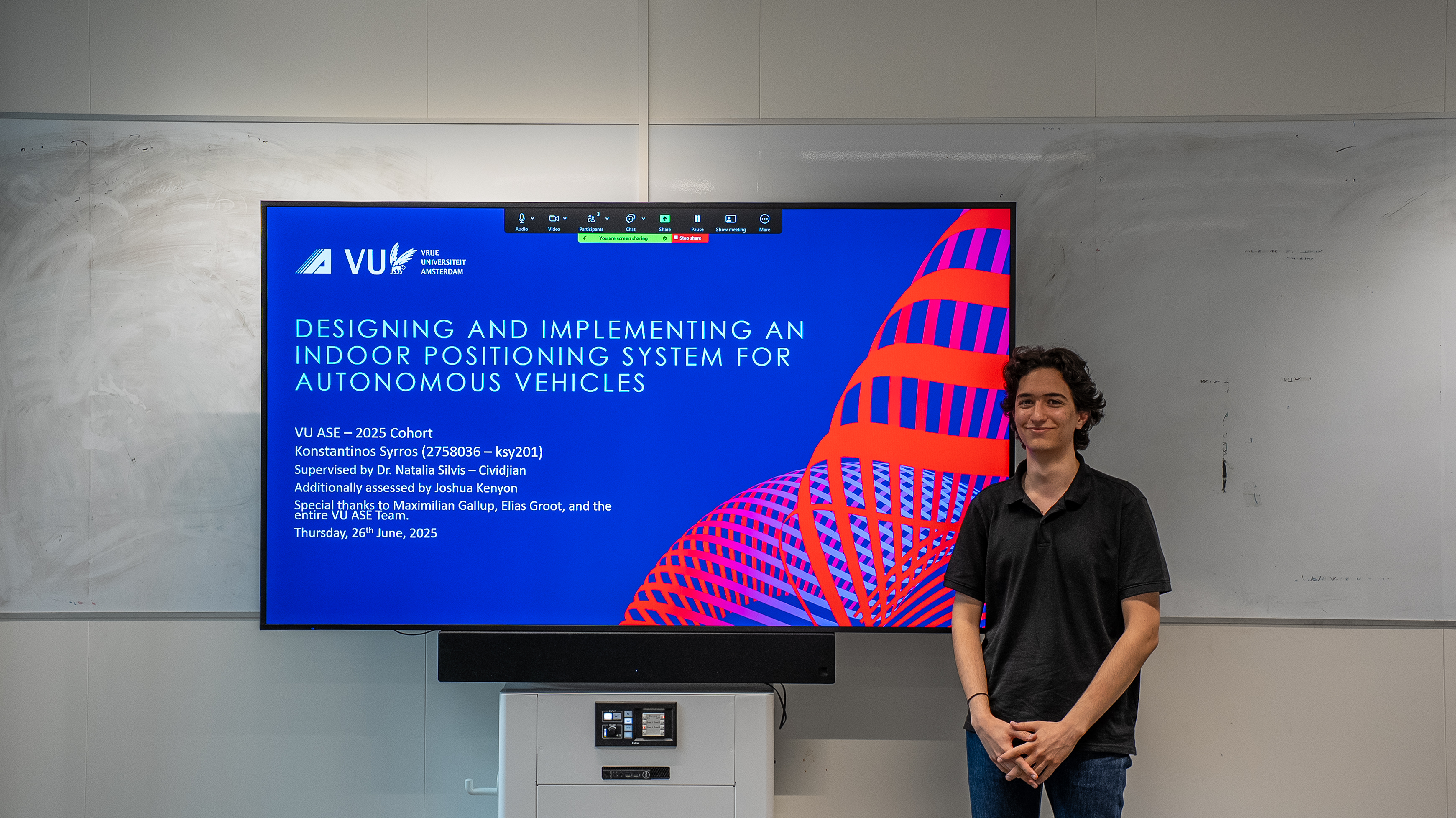 Konstantinos standing in-front of title slide presentation picture